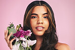 Face of woman, flowers and portrait in studio for skincare, natural spring cosmetics and aesthetic shine on pink background. Model, eco beauty and bouquet of floral plants for sustainable dermatology