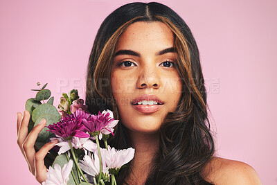 Buy stock photo Face of woman, flowers and portrait in studio for skincare, natural spring cosmetics and aesthetic shine on pink background. Model, eco beauty and bouquet of floral plants for sustainable dermatology