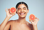 Happy, woman and grapefruit skincare in studio for natural, cosmetic and wellness on grey background. Face, smile and model with citrus, fruit and organic treatment for anti aging, glow or vitamin c