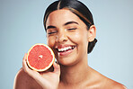 Happy, skincare and woman in studio with grapefruit for natural skin beauty or wellness on grey background. Smile, fruit and female model with citrus cosmetics for vitamin c, collagen and anti aging 