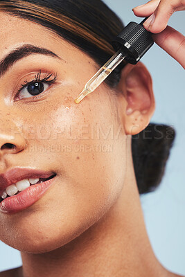 Buy stock photo Woman, face oil and portrait in studio for beauty of aesthetic skincare, dermatology and makeup on blue background. Closeup of model with dropper for facial cosmetics, hyaluronic acid or liquid serum