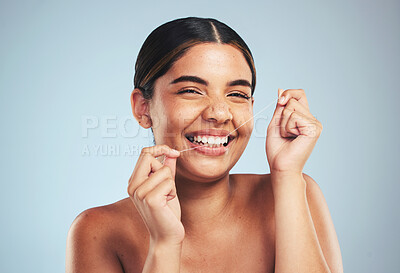 Buy stock photo Woman, portrait and smile to floss teeth in studio for dental hygiene, care and gum gingivitis on blue background. Happy model cleaning mouth with oral thread for fresh breath, healthy habit or tooth
