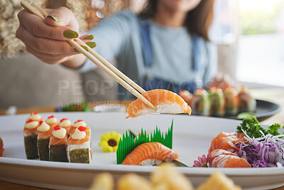 Buy stock photo Hands, chopsticks and woman with sushi in restaurant, fine dining and eating in cafe store. Salmon, stick and person on fish, meat and tempura food in plate for lunch, brunch and healthy seafood meal