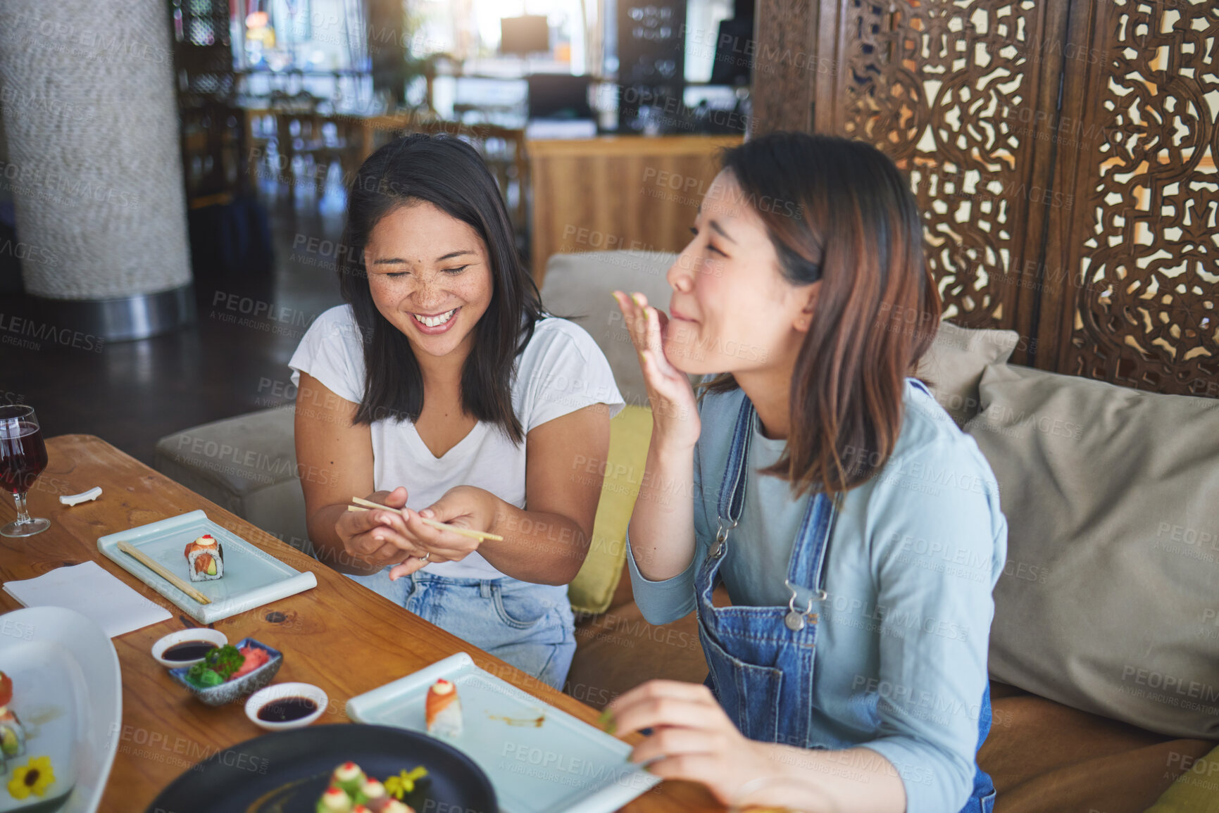 Buy stock photo Girl friends, sushi restaurant and eating together with comic laugh, joke and fail with chopsticks at table. Japanese women, happy and excited with fish, seafood or diner with help, mistake or memory