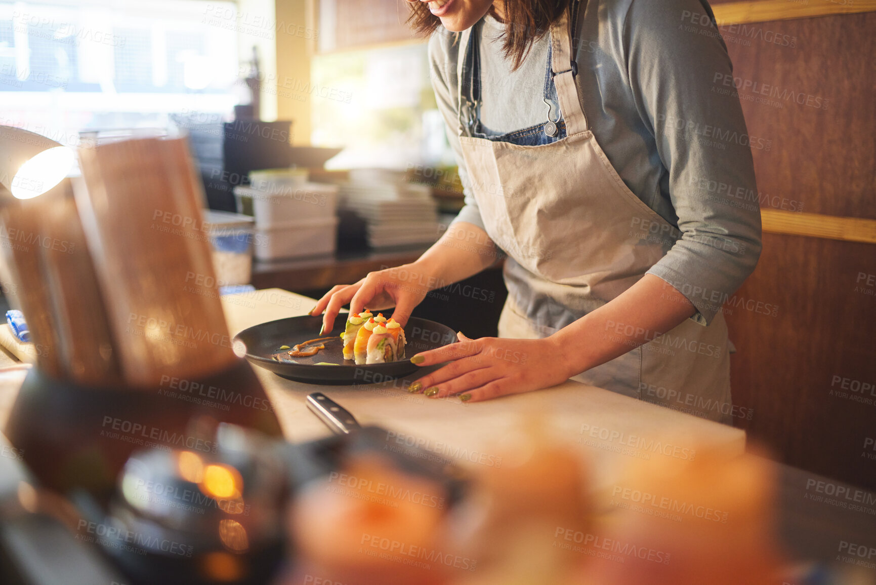 Buy stock photo Sushi chef, restaurant and ready in kitchen with hands, service or plate on table, job or catering. Small business, fast food and cooking in cafe, startup diner and working with fish, rice or seaweed