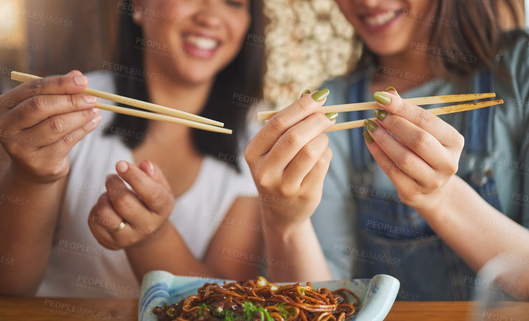 Buy stock photo Chopsticks, restaurant and friends hands with noodles and Asian cuisine at a cafe. Happy, hungry women and plate of food at a Japanese bar with friendship, smile and bonding from meal at a table