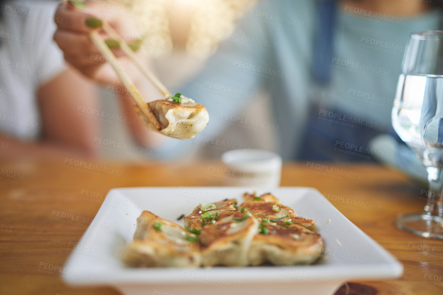 Buy stock photo Table, plate and chopsticks with a dumpling at a restaurant for food, Asian culture or fine dining. Health, hungry and a person with dinner, eating lunch or enjoying a fried dish or cuisine at a cafe