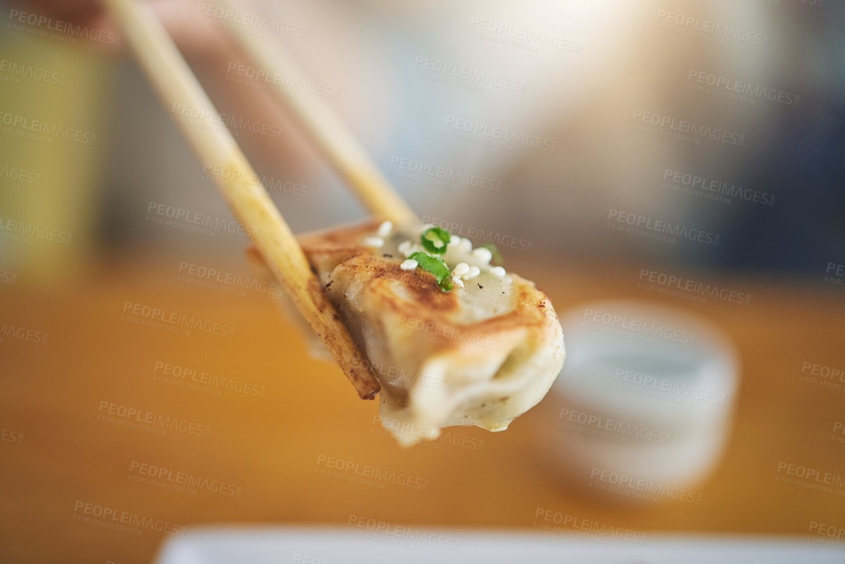 Buy stock photo Closeup, protein and chopsticks with dumpling at a restaurant for food, Asian culture or fine dining. Health, hungry and person with dinner, eating lunch or enjoying a fried dish or cuisine at a cafe