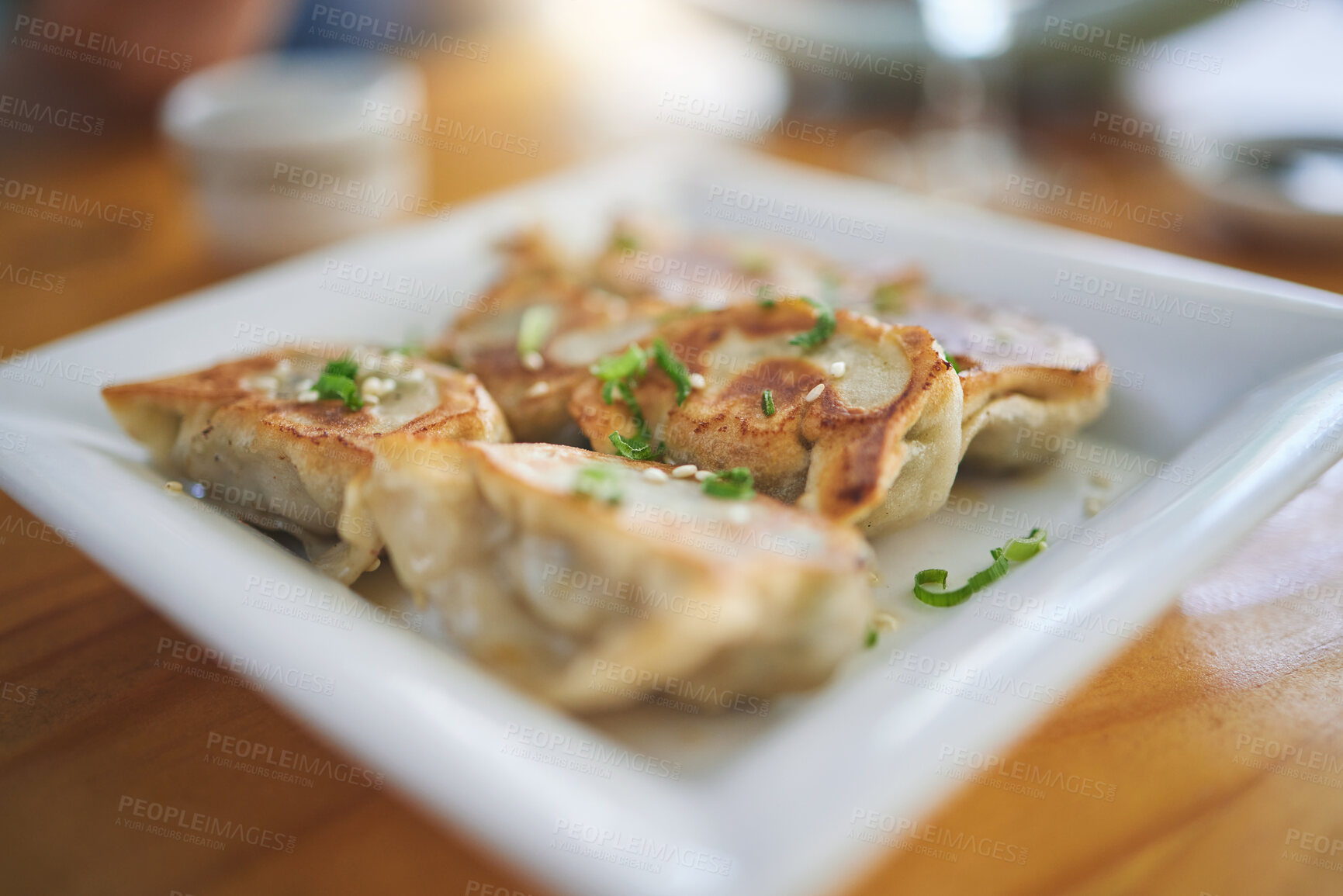 Buy stock photo Closeup, plate and dumplings for lunch at a restaurant, Chinese food or Asian cuisine. Zoom, protein and dinner on a table at a cafe for fine dining, eating or an appetizer or enjoying a meal