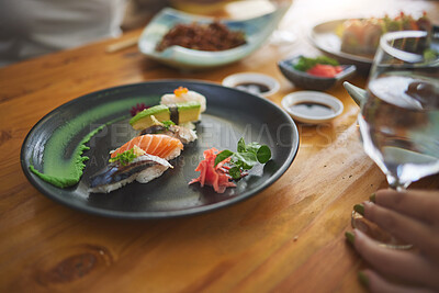 Buy stock photo Plate, table and sushi with a person at a restaurant for fish, lunch or seafood dinner. Closeup, hungry and people at a cafe for fine dining, Chinese food or eating Asian cuisine for a meal together