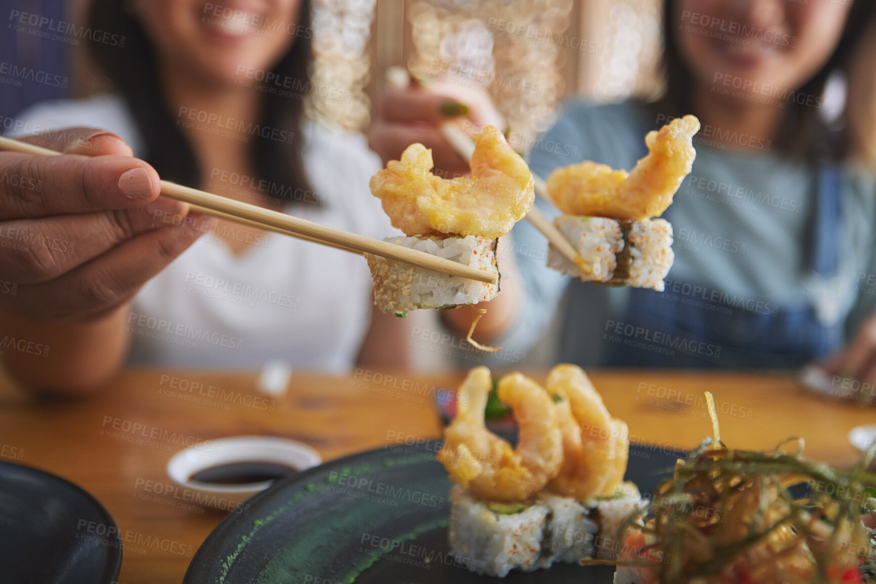 Buy stock photo Chopsticks, woman hands and shrimp sushi closeup at a table with Japanese cuisine food at restaurant. Young women, eating and tempura prawn with fish for lunch and meal on a plate with a smile