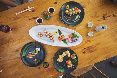 Buy stock photo Sushi, seafood and chopsticks in an asian restaurant from above for fine dining or traditional cuisine. Salmon, menu and chinese food with a dish on a table in a local eatery for hunger or nutrition