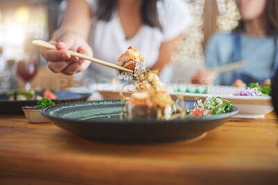 Buy stock photo Sushi, hand and eating food with chopsticks at a restaurant for nutrition and health. Closeup of a hungry people with wooden sticks for dining, Japanese culture and cuisine with creativity on plate