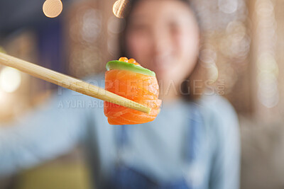 Buy stock photo Food, eating sushi and person with chopsticks at restaurant for nutrition and health. Closeup of a woman with wooden sticks for dining, Japanese culture and salmon cuisine with creativity on fish