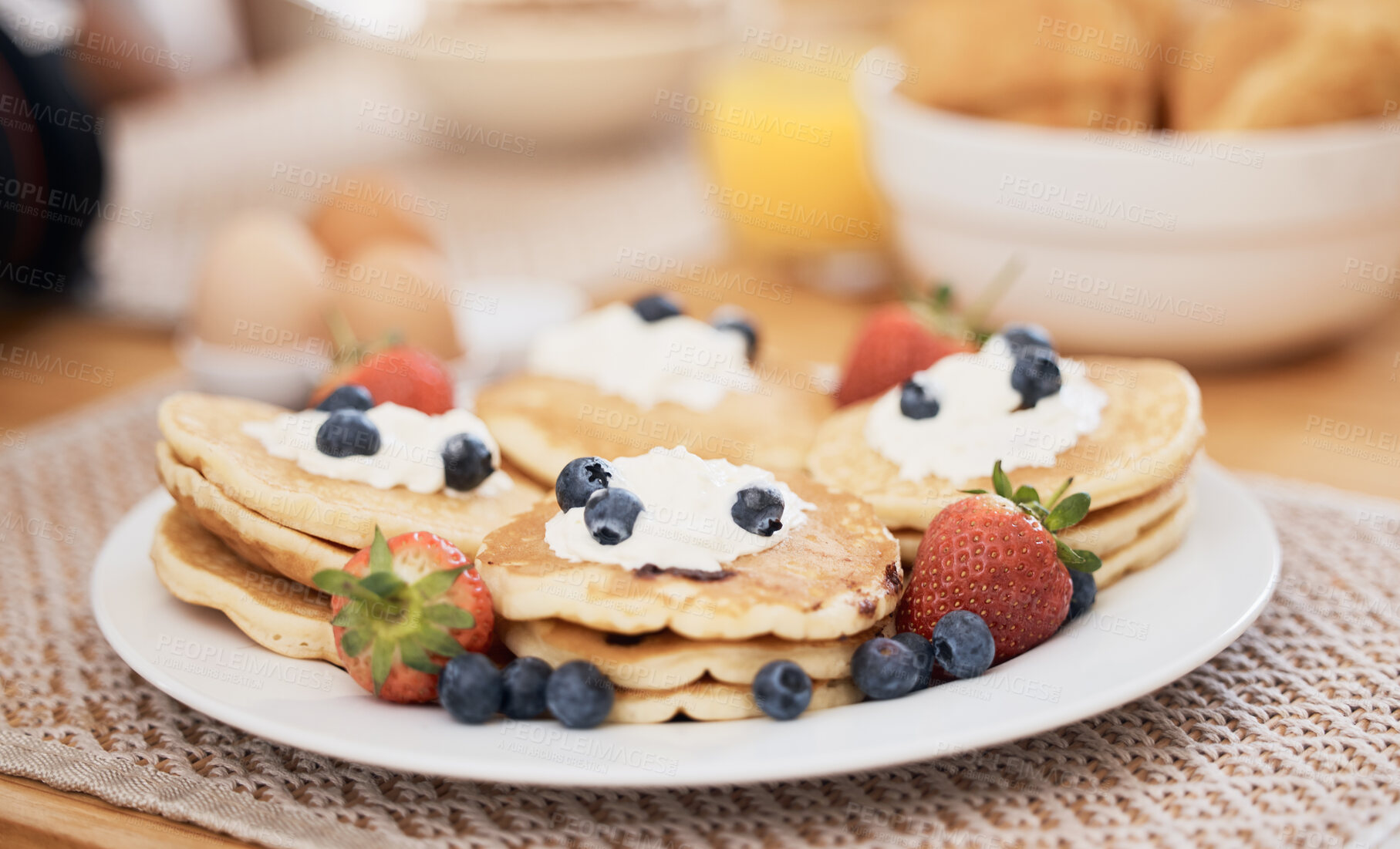 Buy stock photo Pancakes, breakfast and fruits on table in home in the morning for protein. Bread waffle, cream and food for eating, healthy diet and strawberry in wellness nutrition, blueberry and egg meal on plate