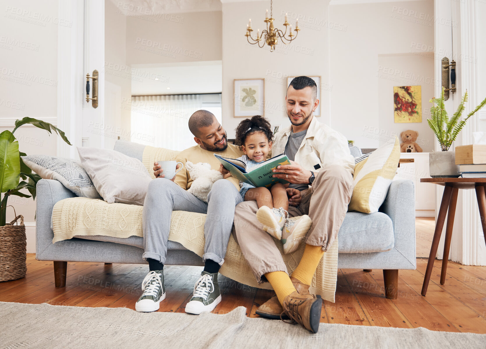 Buy stock photo Gay parents on a couch, girl and reading book with a smile, home and education with bonding, relax and weekend break. Fathers, female child and kid with lgbtq, storytelling and fairytale in a lounge