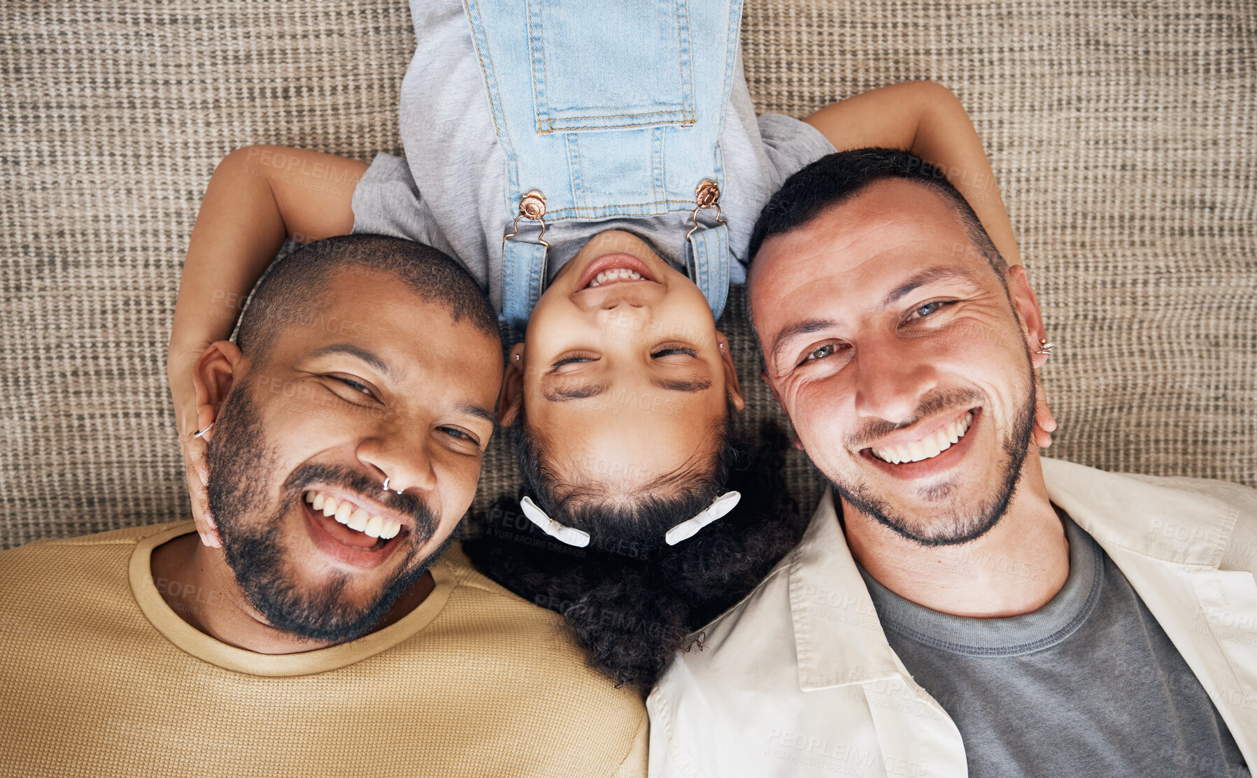 Buy stock photo Gay dad, blended family and foster with a girl lying together on the floor of the home for adoption from above. LGBT love, children or kids and a daughter bonding with her happy parents in the house