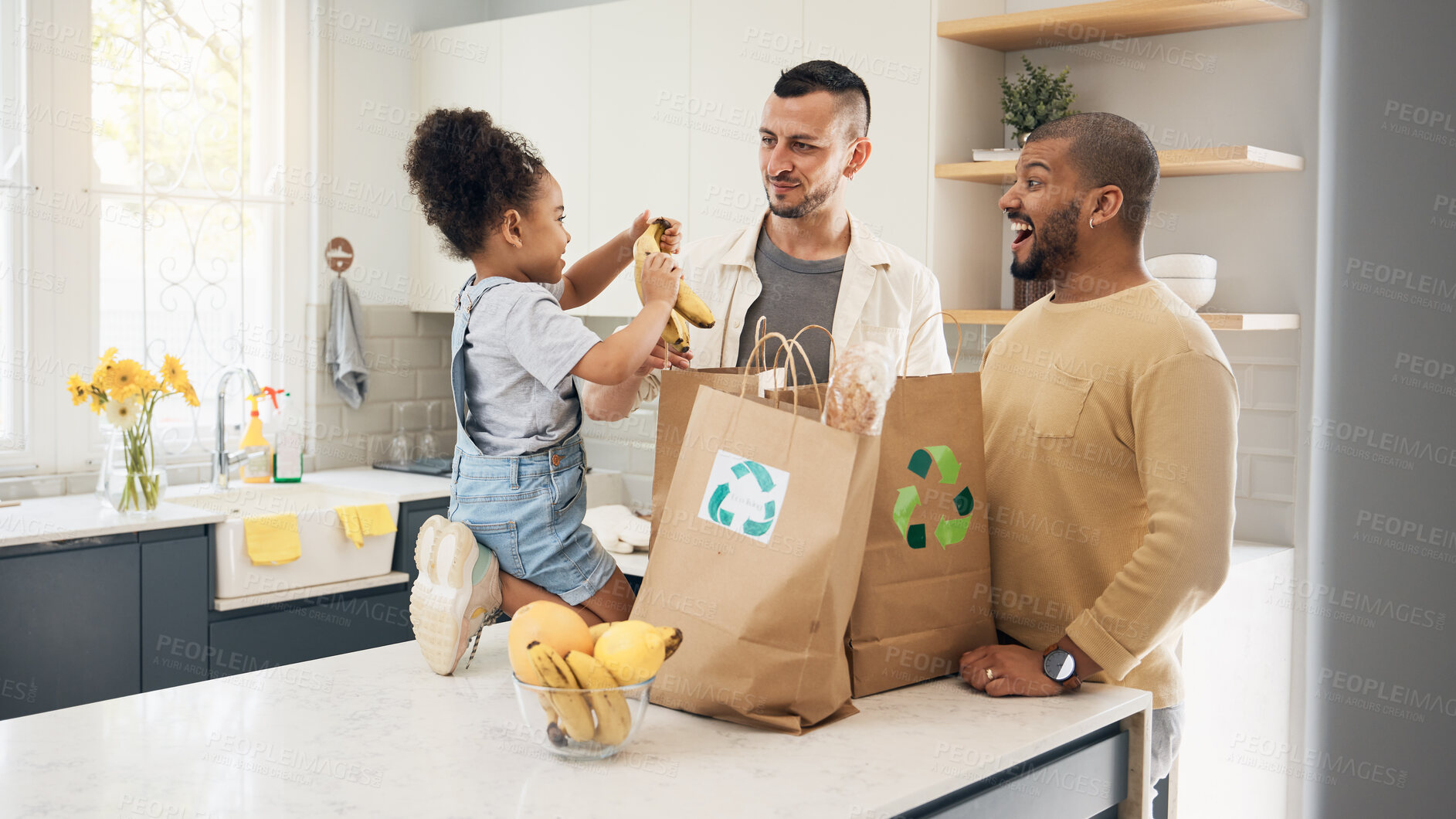 Buy stock photo Recycling, blended family or adoption with a girl and gay couple in the home kitchen for sustainability. LGBT, eco friendly or waste with a daughter and parents unpacking bananas from a grocery bag