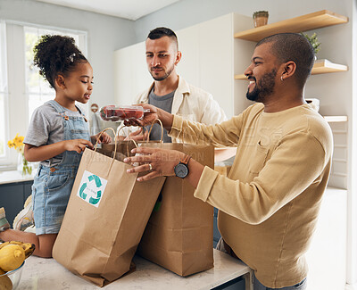 Buy stock photo Happy family, shopping and bags of groceries in home and curious, excited girl with gay parents, dad and father in kitchen. Sustainable, paper bag and kid with eco friendly grocery, product or fruit