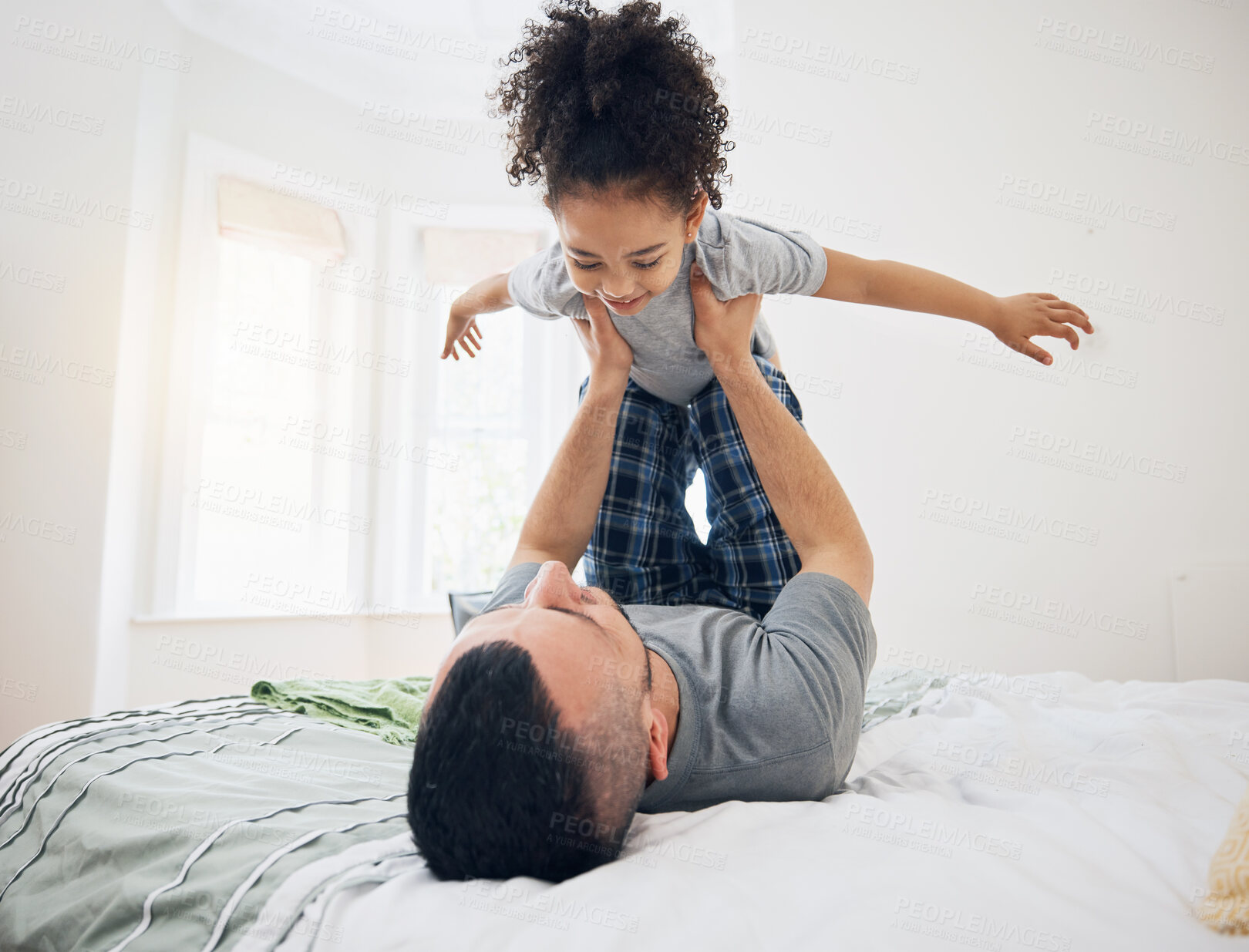 Buy stock photo Happy, fun and dad with child on bed playing, bonding and airplane game for father and daughter in home. Family, love and playful energy, man holding girl in air and laughing in bedroom together.