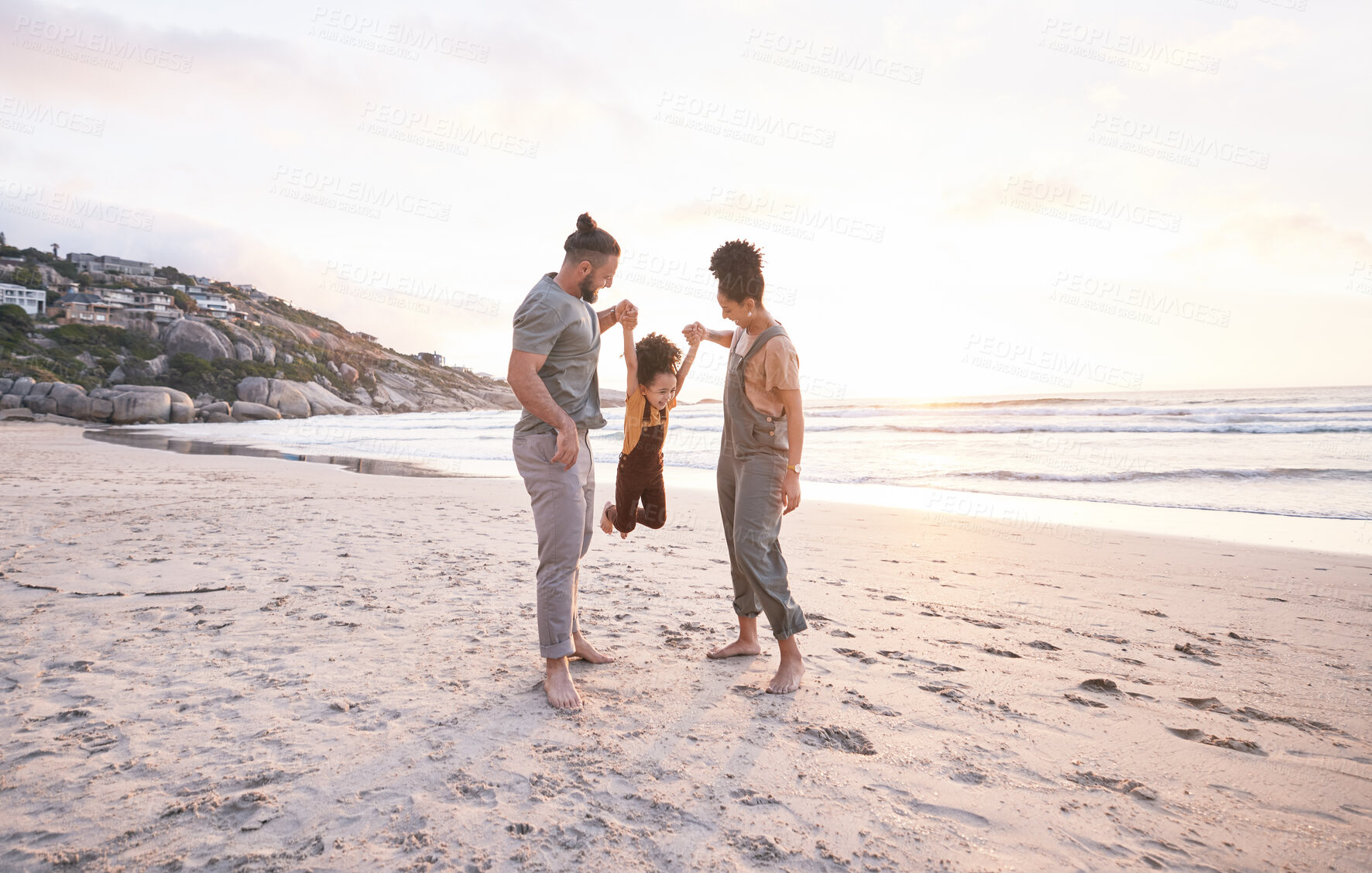 Buy stock photo Sunset, swing and holding hands with family at beach for bonding, summer vacation and travel. Smile, happy and relax with parents and child walking on seaside holiday for love, freedom and support