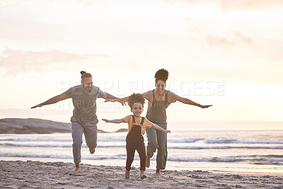 Buy stock photo Travel, freedom and a family at the beach during sunset for flying, playing and bonding at the ocean. Smile, holiday and an interracial child, mother and father at the sea for a vacation or summer