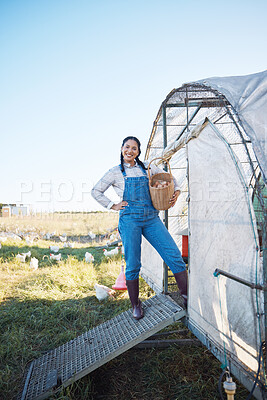 Buy stock photo Smile, woman and eggs in basket on farm with chicken, grass and sunshine in countryside field for sustainable business. Agriculture, poultry farming and happy farmer with food in nature and coop.