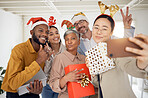 Business people, Christmas selfie and happy staff with present, peace sign or celebration for diversity at party. Men, women and photography for funny xmas memory, friends or gift for social network