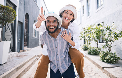Buy stock photo Happy interracial couple, travel or piggyback in city on romantic date to play a fun outdoor game. Smile, pointing or excited black man carrying gen z woman or walking for urban sightseeing together
