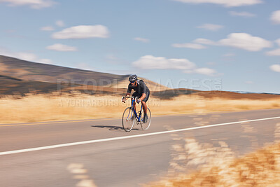 Buy stock photo Road, nature and man cycling fast for workout, exercise and scenic mountain path with motion. Health, wellness and cyclist on speed bike for morning training, practice and bicycle race with blue sky.