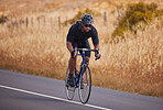 Fitness, nature and bicycle, man on road for workout exercise and scenic mountain path. Health, wellness and cyclist on bike on summer morning for training, practice and cycling race with blue sky.