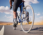 Road, closeup and man on a bike for cycling, race training or travel in the countryside. Health, exercise and legs of male cyclist or athlete with a bicycle for a workout, street cardio or triathlon