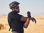 Fitness, nature and man cyclist stretching arms for race, marathon or competition training. Sports, cycling and male athlete doing warm up exercise for health at an outdoor cardio workout by mountain