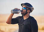 Fitness, health and man cyclist drinking water at race, marathon or competition training. Sports, workout and thirsty male athlete with hydration for wellness at an outdoor cardio exercise in nature.