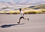 Fitness, running and motion blur with a sports man on a road for his cardio or endurance workout. Exercise, health and a runner training for a marathon or challenge in the mountains during summer
