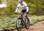 Fast, fitness and man on a bike in nature for a race, sports or fitness. Energy, mountains and a male cyclist on a bicycle in the woods with speed for exercise, cardio or training in a forest