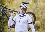 Athlete, man and carrying mountain bike outdoor for cardio exercise, sports race and training in nature. Mature cyclist walking with bicycle, focus and thinking of cycling adventure on off road path