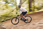 Blur fast, cycling and man in nature training for a race, marathon or competition in forest. Adventure, fitness and cyclist athlete riding bicycle at speed on mountain for cardio exercise or workout.