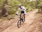 Cycling, fitness and man with bicycle in a forest for speed, training or workout in nature for off road hobby. Extreme sports, mountain bike and cyclist in woods for workout or adrenaline performance