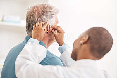 Buy stock photo Doctor, helping and man with hearing aid, technology or healthcare or medical device consultation for deaf patient with tinnitus. Listening, test and exam ear tech with nurse or senior male in clinic