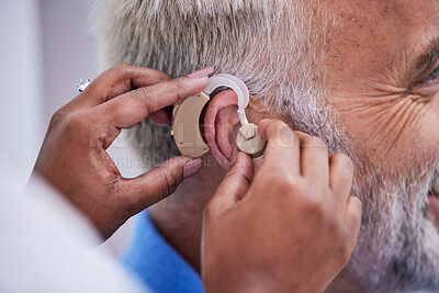 Buy stock photo Healthcare, hands and doctor with hearing aid for man for communication support. Closeup, medical and a nurse with an implant for a patient with a disability for help with listening and conversation