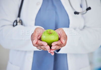 Doctor, hands and apple in healthcare diet, natural nutrition or healthy vitamin food at the hospital. Closeup of medical professional holding organic green fruit for health and wellness at clinic