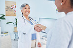 Happy doctor, handshake and meeting patient in healthcare, visit or appointment at the hospital. Mature female person or medical professional shaking hands with customer in greeting or consultation