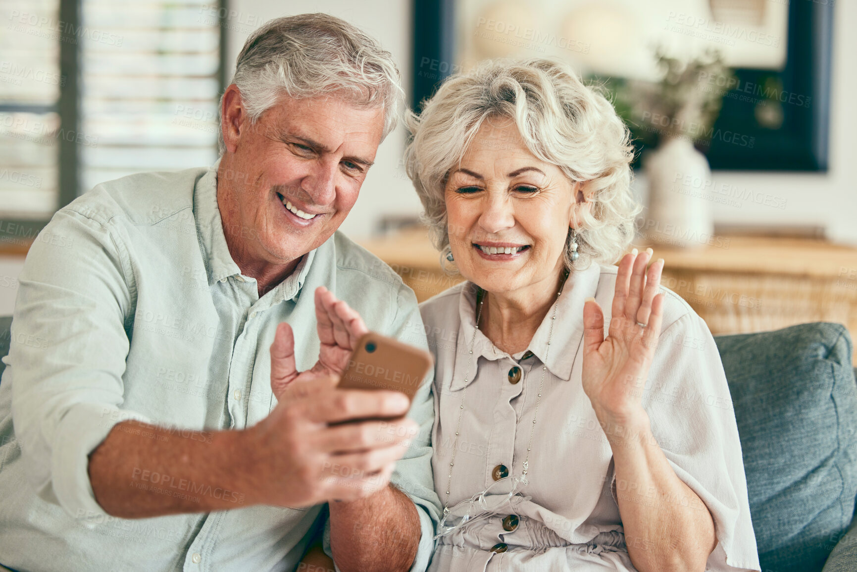 Buy stock photo Video call, hello and smile with old couple and phone on sofa for streaming, social media and communication. Network, internet and wave with senior man and woman in living room at home for mobile app