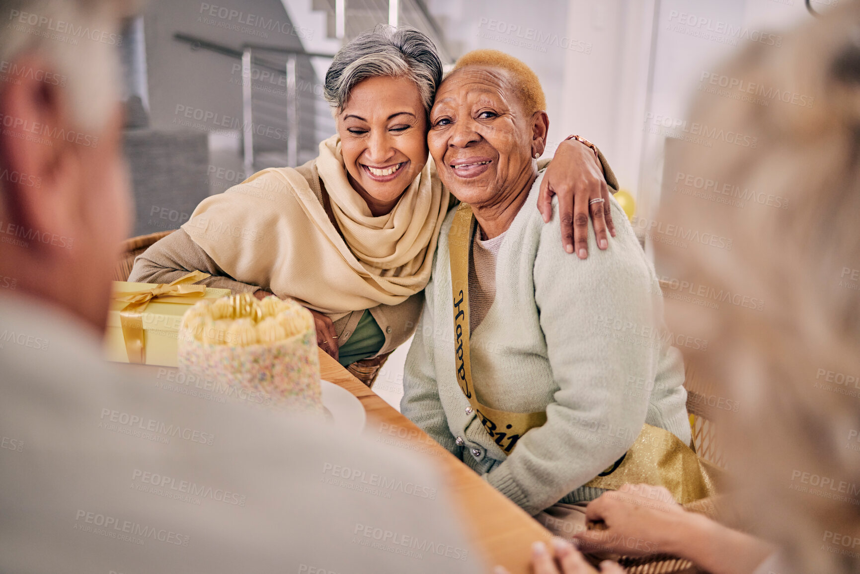 Buy stock photo Happy, smile and senior friends hugging at a birthday party, celebration or event at retirement home. Excited, bonding and elderly women embracing with love, care and happiness in a modern house.