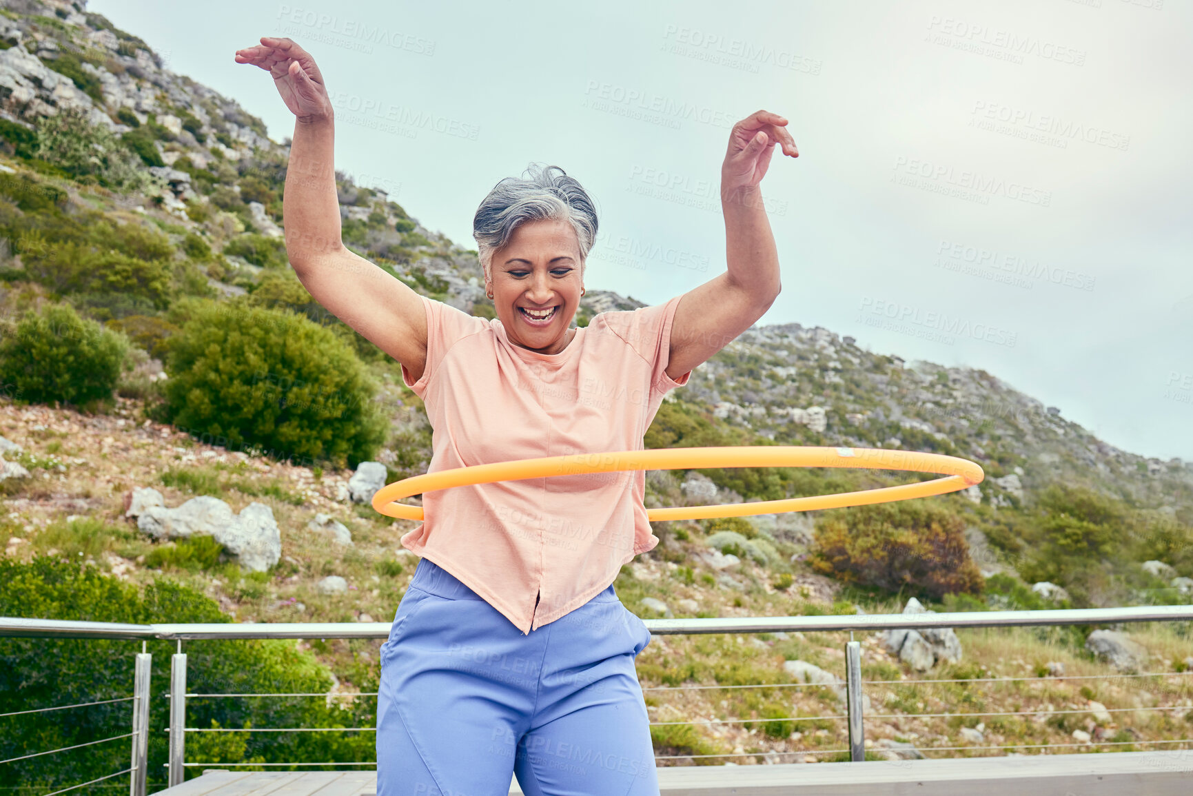 Buy stock photo Senior woman, hoop and fitness outdoor with smile, training and playful on balcony, mountains and healthy. Mature lady, exercise and happy for wellness, stomach workout and toys on rooftop in Hawaii