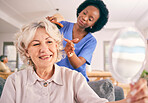 Caregiver brush hair of happy senior woman in the living room of the modern retirement home for self care. Mirror, routine and African female nurse doing a hairstyle for an elderly patient in lounge.