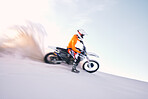 Bike, dust and motion blur with a sports man riding a vehicle in the desert for adventure or adrenaline. Motorcycle, training and speed with an athlete on sand in nature for speed, freedom or energy