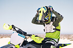 Sports, action and man on motorbike in desert for training, workout and race challenge on sand. Extreme transport, travel and cyclist with helmet on motorcycle for adventure, freedom and adrenaline