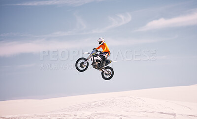 Buy stock photo Motorcycle, sky and jump with a man in the desert riding a vehicle for adventure or adrenaline. Bike, speed and training on sand with an athlete in the air in nature for freedom or active competition